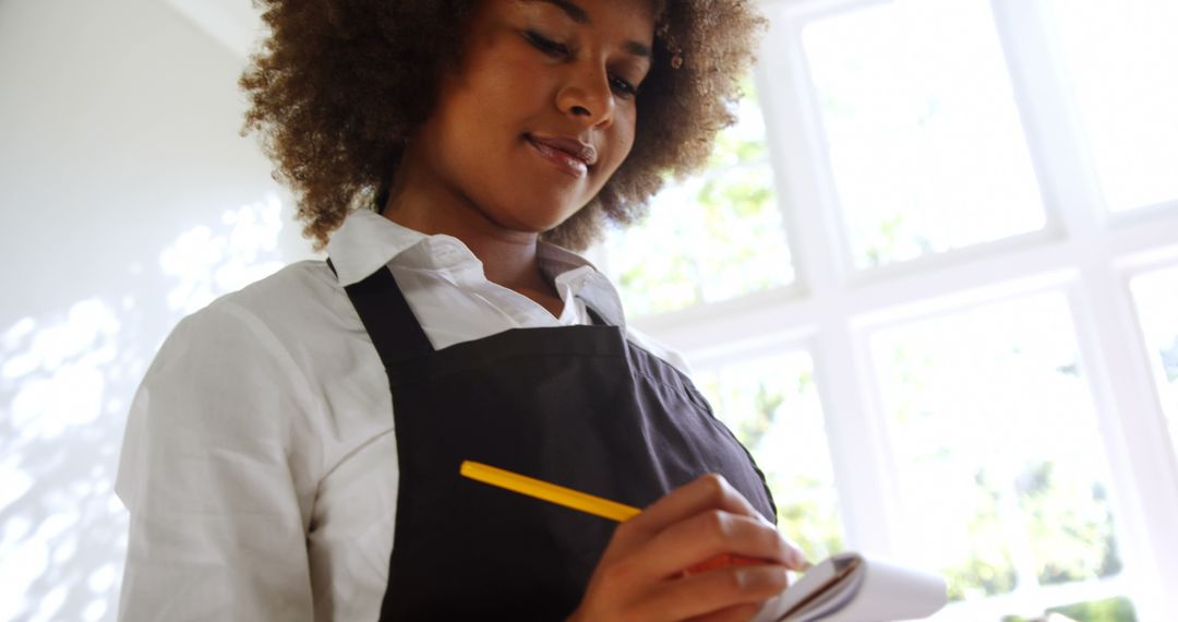 African American waitress writing down order in restaurant - Free Images, Stock Photos and Pictures on Pikwizard.com