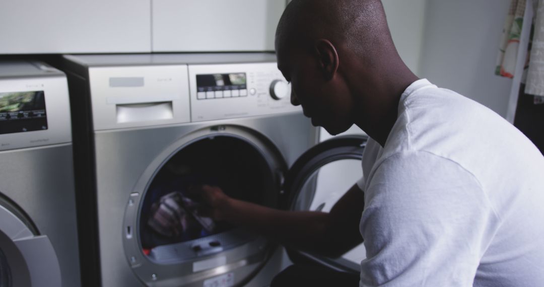 Man doing laundry at home in modern utility room - Free Images, Stock Photos and Pictures on Pikwizard.com