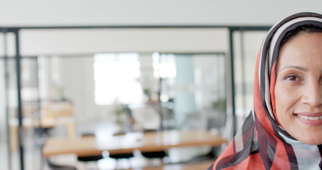 Professional businesswoman in headscarf smiling at office