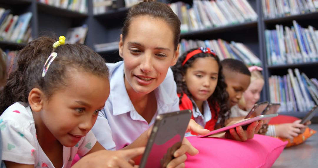 Teacher Guiding Students on Tablets in School Library