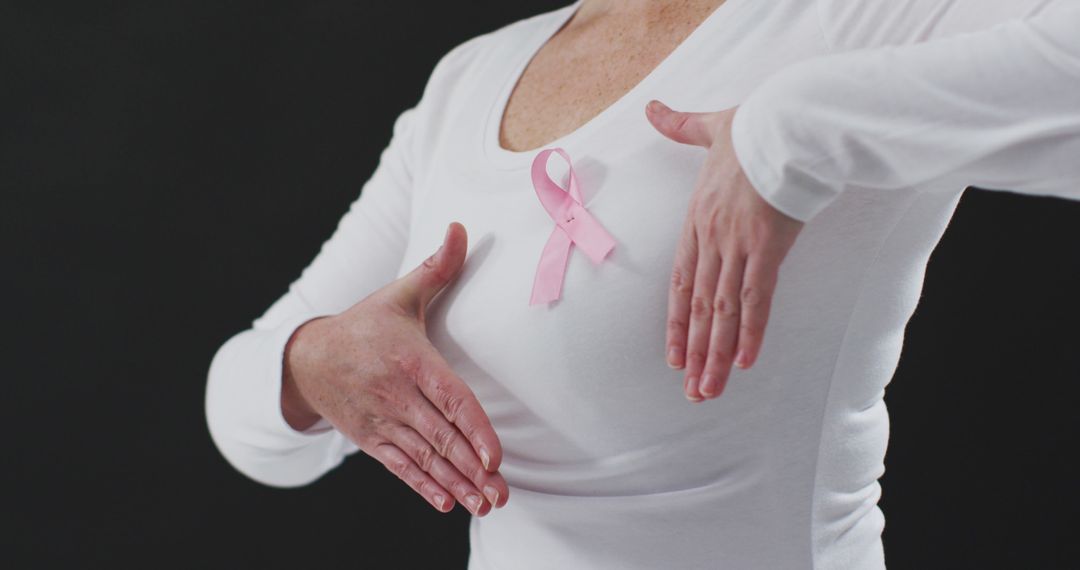 Woman Wearing Pink Ribbon Performing Breast Cancer Self-Exam - Free Images, Stock Photos and Pictures on Pikwizard.com