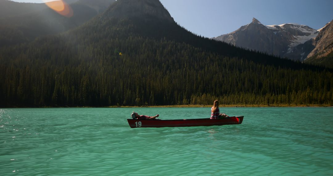 Couple Canoeing on Turquoise Lake with Mountain View - Free Images, Stock Photos and Pictures on Pikwizard.com