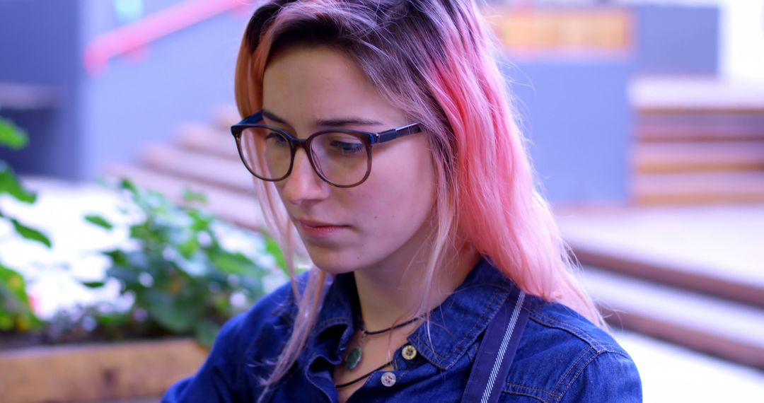 Young Woman with Pink Hair and Glasses Concentrating Outdoors - Free Images, Stock Photos and Pictures on Pikwizard.com