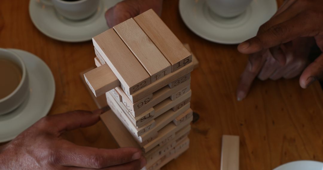 Hands Playing Jenga Game at Wooden Table - Free Images, Stock Photos and Pictures on Pikwizard.com