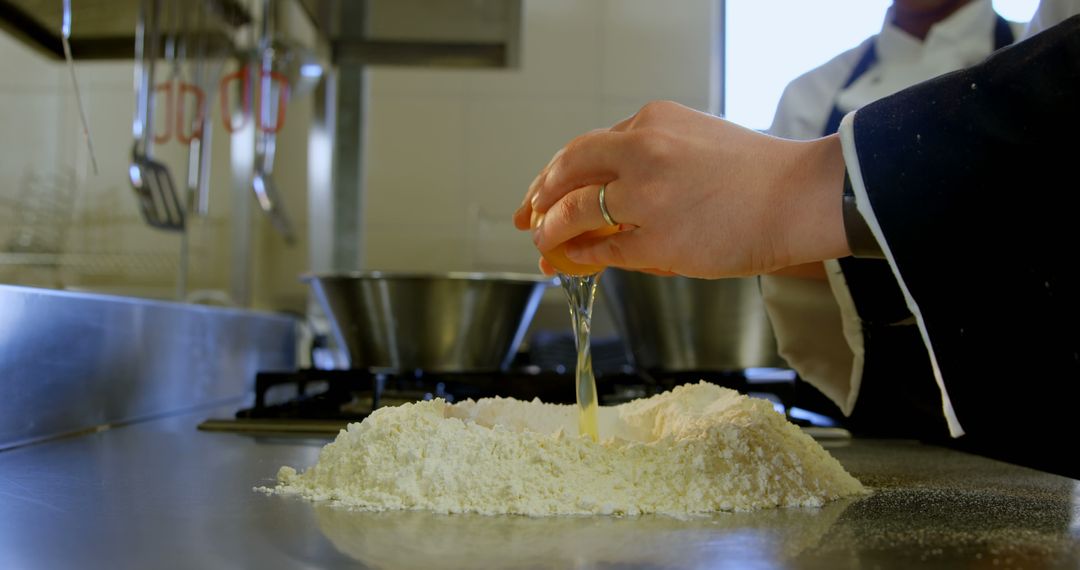 Chef Cracking Egg Over Flour In Professional Kitchen - Free Images, Stock Photos and Pictures on Pikwizard.com