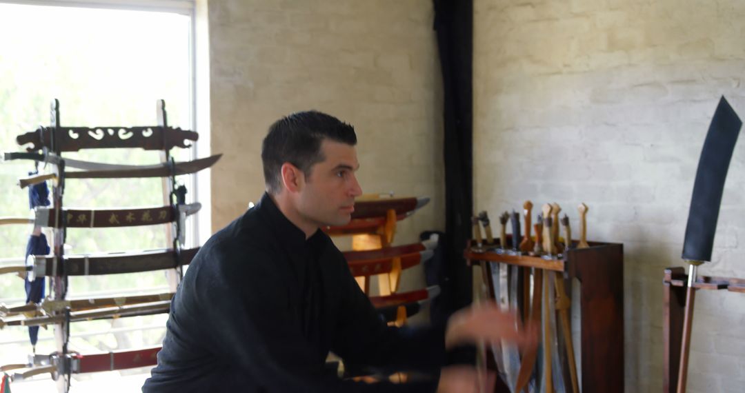 Man Practicing Martial Arts in Dojo with Swords Displayed - Free Images, Stock Photos and Pictures on Pikwizard.com