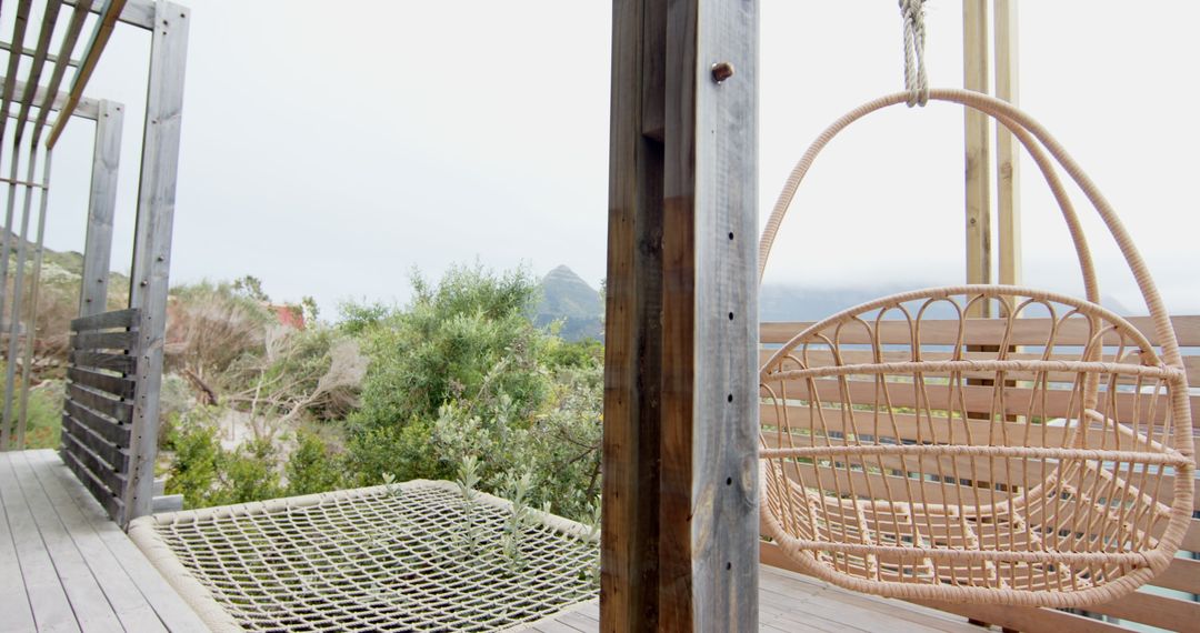 Wicker Hanging Chair and Rope Hammock on Tranquil Wooden Deck
