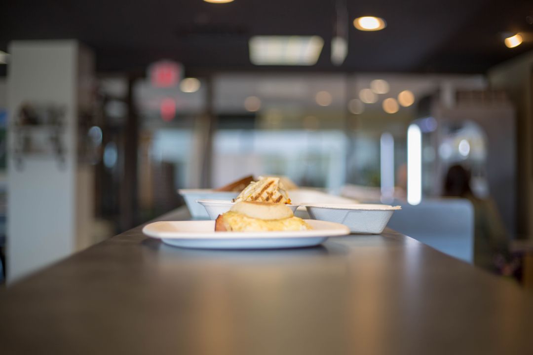 Breakfast Sandwich on Plate Sitting on Cafe Counter with Soft Bokeh Background