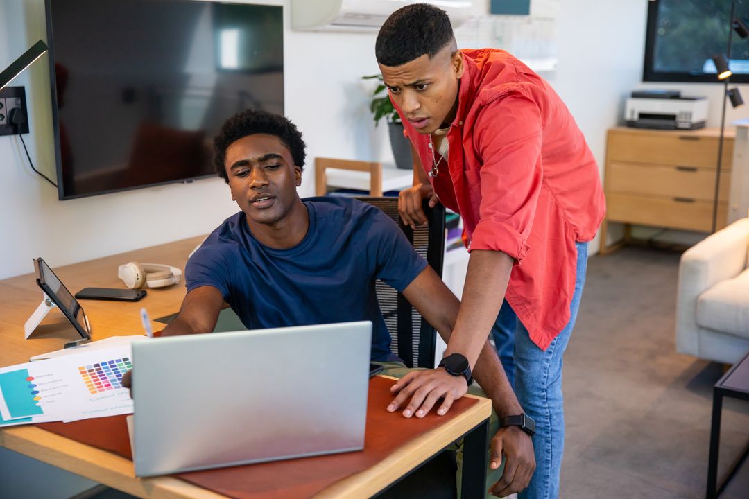 Diverse Team Collaborating on Design Project with Laptop