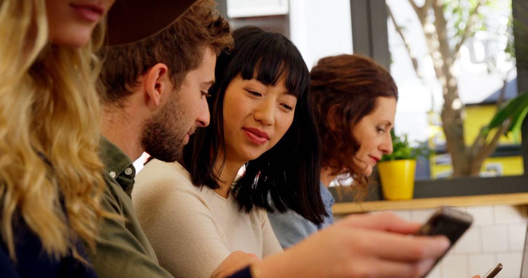 Diverse Young Adults Conversing and Using Smartphones Together