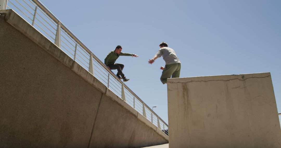 Two Parkour Enthusiasts Practicing Jumping Between Urban Structures - Free Images, Stock Photos and Pictures on Pikwizard.com