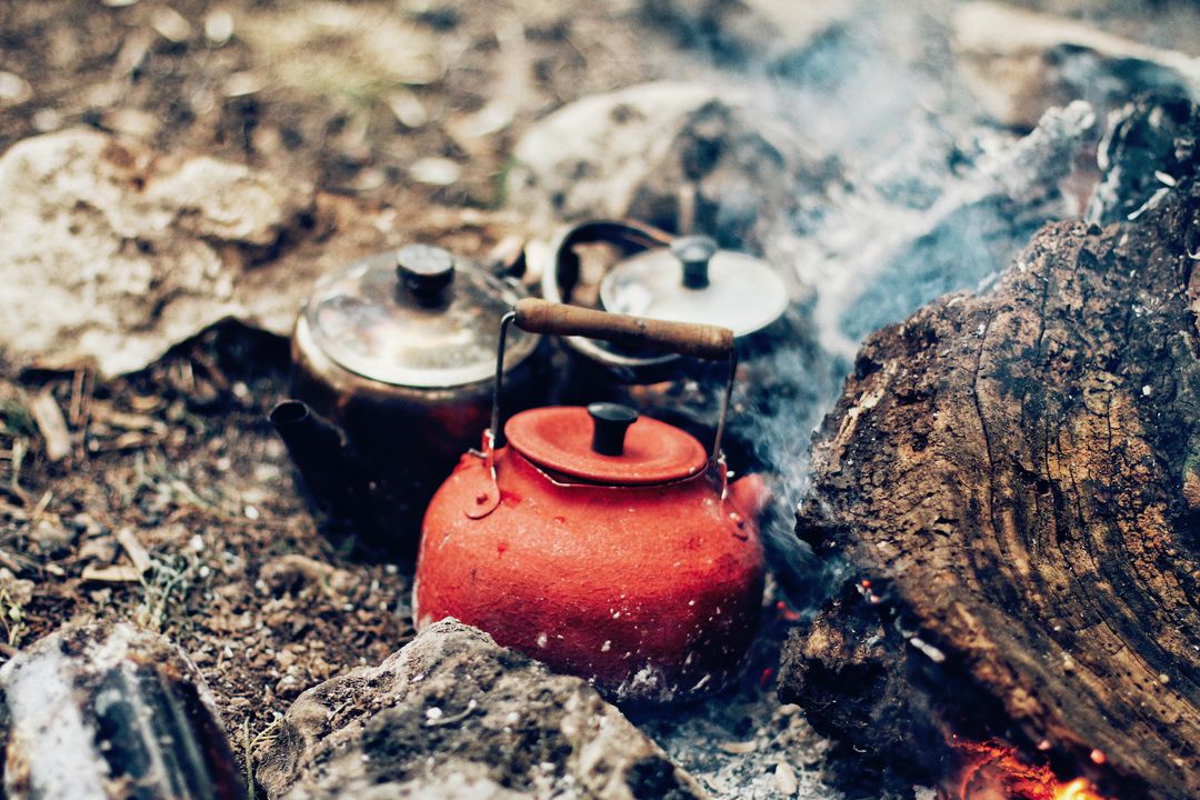 Camping Scene with Red Kettle on Open Fire in Forest