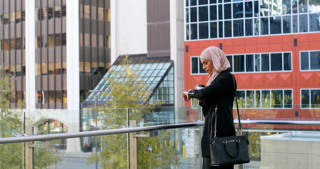 Busy Muslim Woman Checking Time on Watch in Urban Cityscape - Free Images, Stock Photos and Pictures on Pikwizard.com