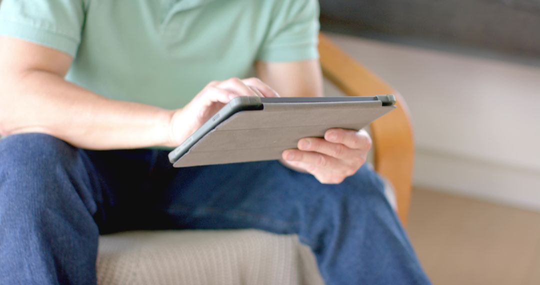 Digital Lifestyle: Man Relaxing on Sofa with Tablet in Modern Home
