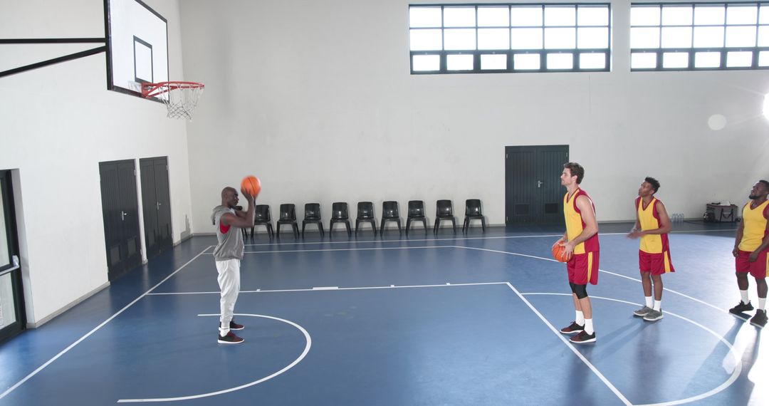 Basketball Players Practicing Free Throw Technique on Indoor Court