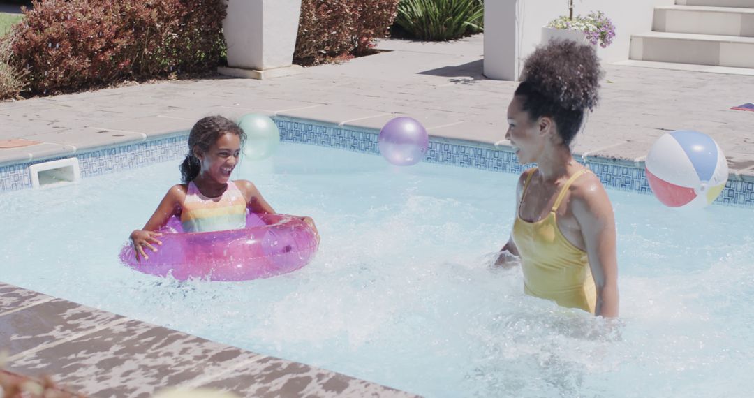 Mother and Daughter Enjoying Pool Time with Floaties and Beach Balls - Free Images, Stock Photos and Pictures on Pikwizard.com