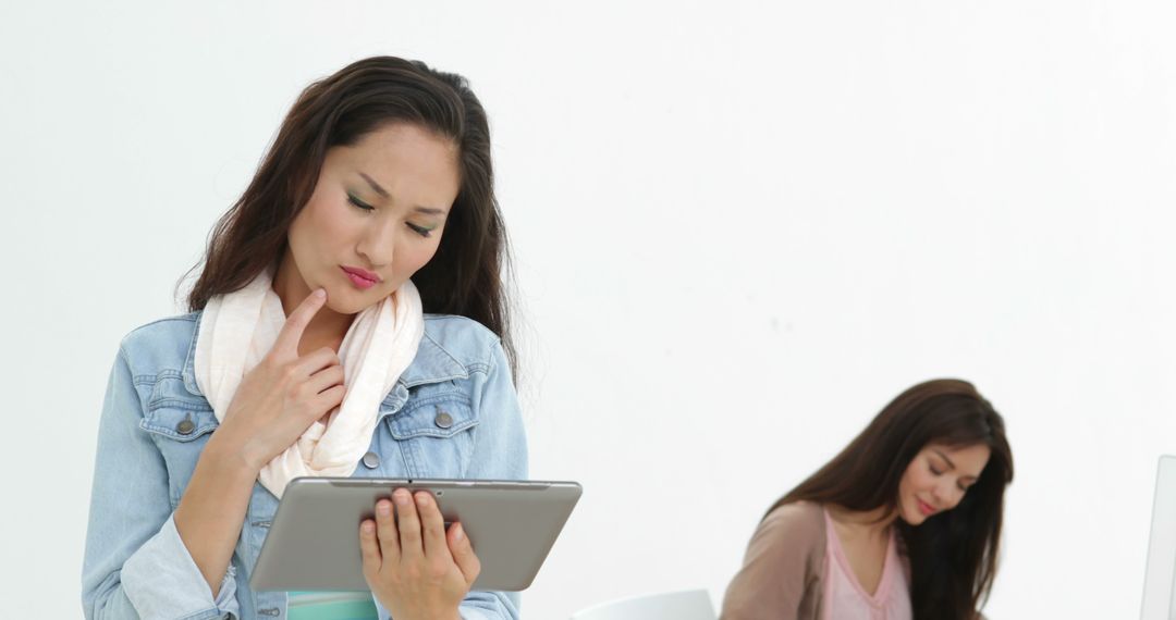 Pensive Businesswoman Using Tablet in Modern Design Studio