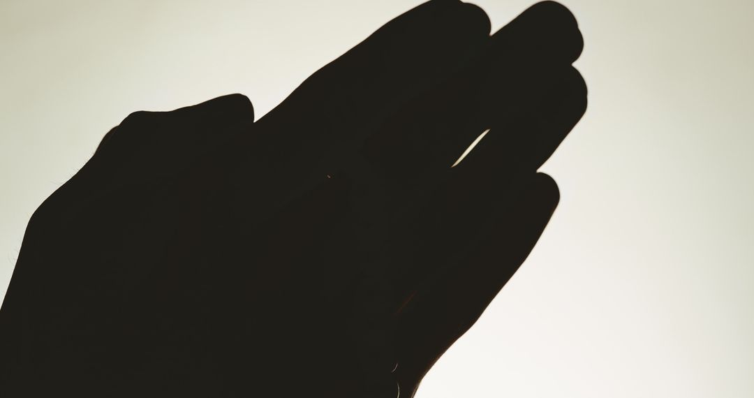 Silhouette of Praying Hands with Rosary and Cross on Grey Background