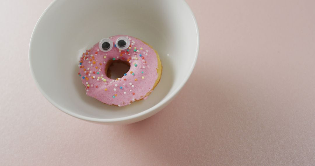 Pink Frosted Donut with Eyes in Bowl on Pink Background - Free Images, Stock Photos and Pictures on Pikwizard.com