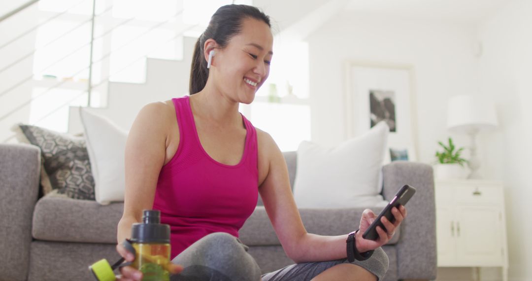 Smiling Woman Taking Break with Smartphone After Home Workout - Free Images, Stock Photos and Pictures on Pikwizard.com