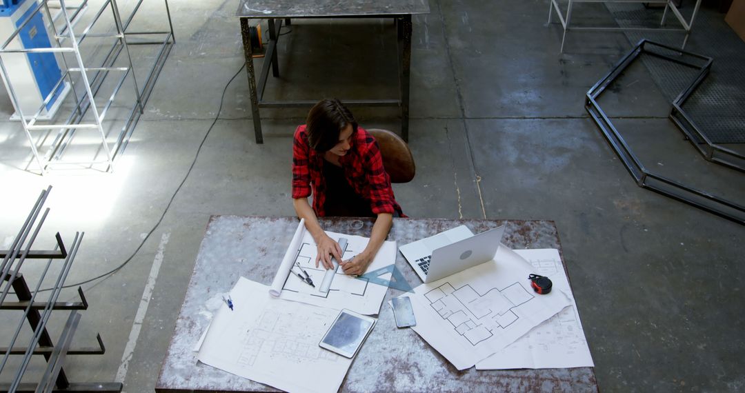 Architect Working on Blueprints in Industrial Workshop - Free Images, Stock Photos and Pictures on Pikwizard.com