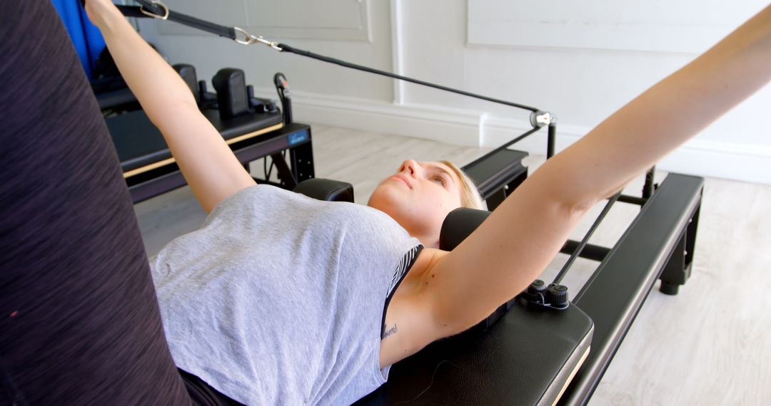 Woman Practicing Pilates on a Reformer Machine Indoors - Free Images, Stock Photos and Pictures on Pikwizard.com