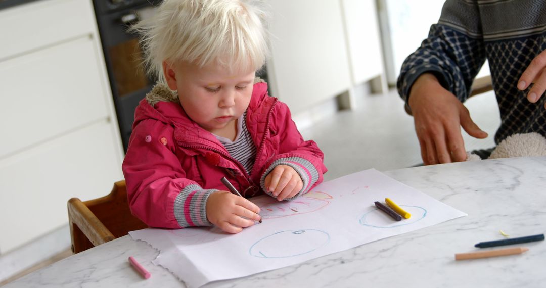 Little Girl Drawing with Crayons at Home
