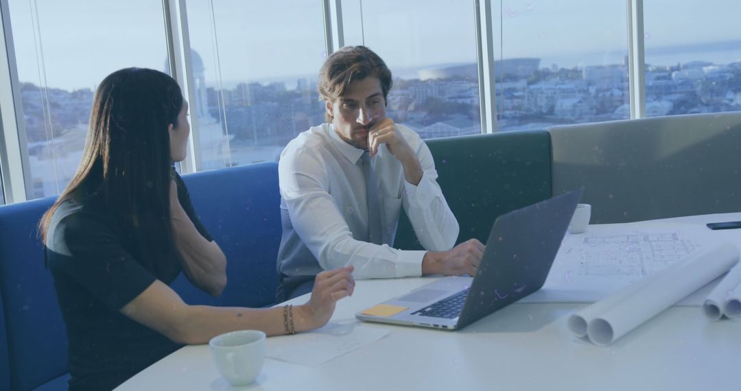Business Colleagues Collaborating on Project with Laptop and Blueprints