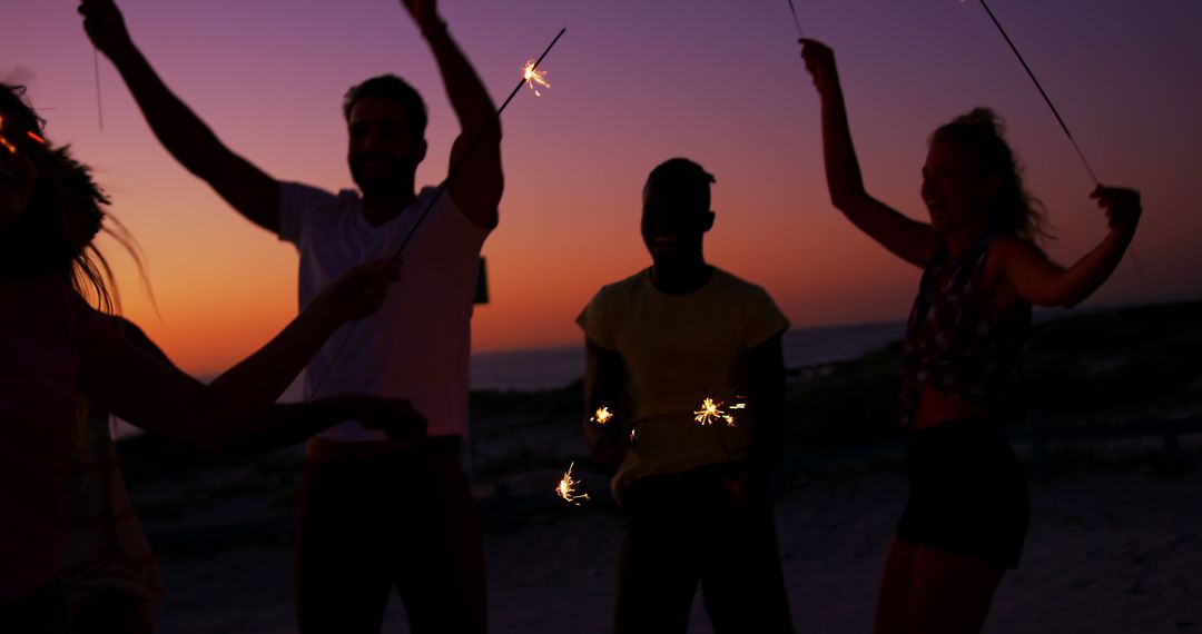 Group of Friends Enjoying Sunset with Sparklers on Beach - Free Images, Stock Photos and Pictures on Pikwizard.com