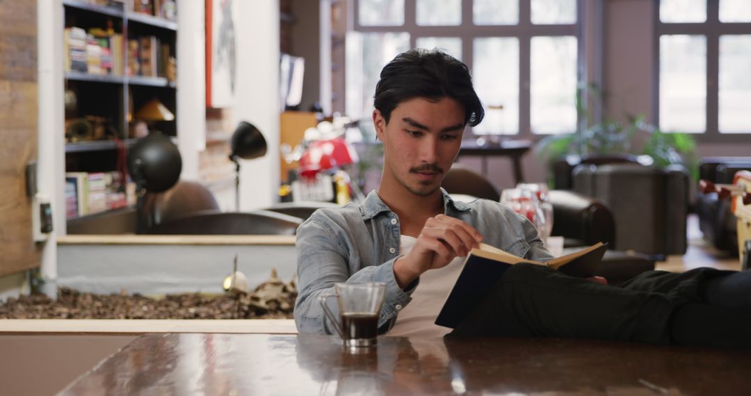 Relaxed Man Reading Book at Home with Coffee