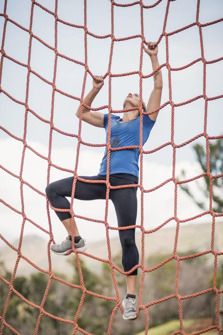 Fit Woman Climbing Net in Outdoor Obstacle Course - Free Images, Stock Photos and Pictures on Pikwizard.com