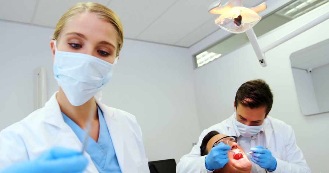 Dentist Team Treating Female Patient in Dental Clinic - Free Images, Stock Photos and Pictures on Pikwizard.com