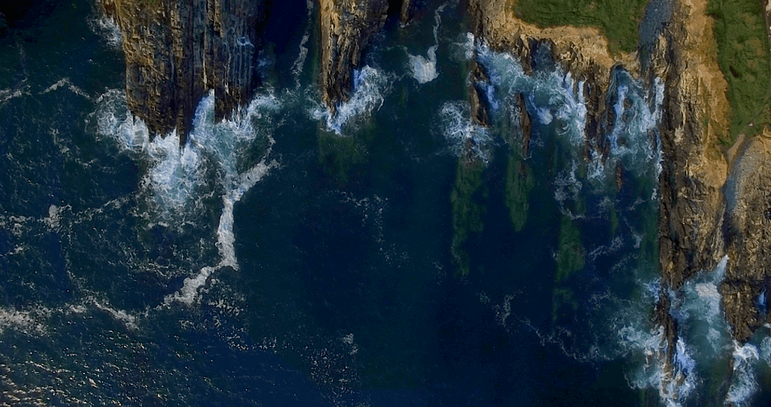 Stunning Aerial View of Rugged Island Cliffs and Transparent Waves