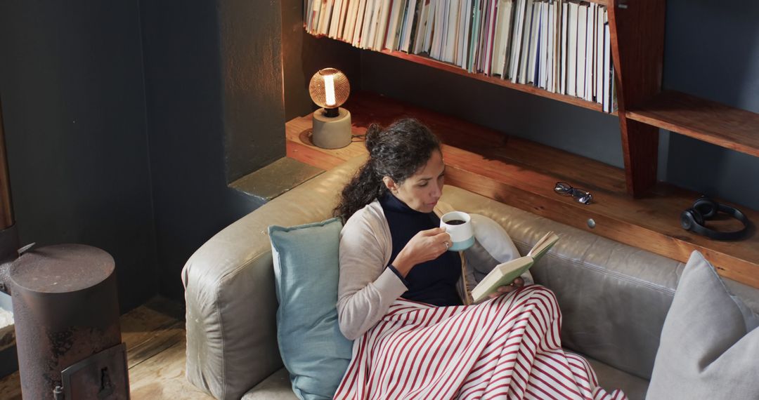 Woman Relaxing with Coffee and Book in Cozy Home Environment - Free Images, Stock Photos and Pictures on Pikwizard.com