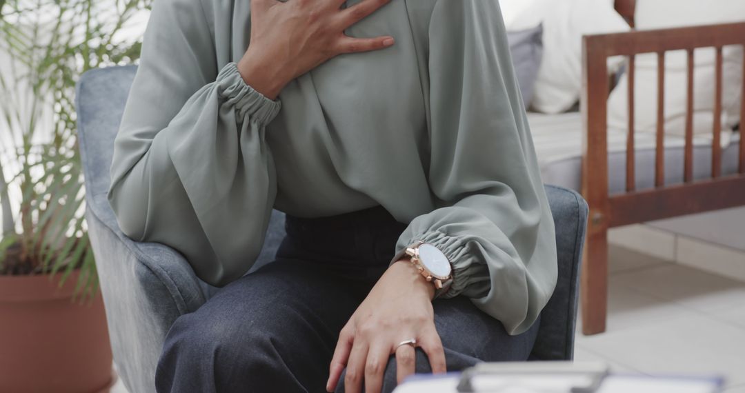 Woman Experiencing Chest Pain While Sitting Indoors - Free Images, Stock Photos and Pictures on Pikwizard.com