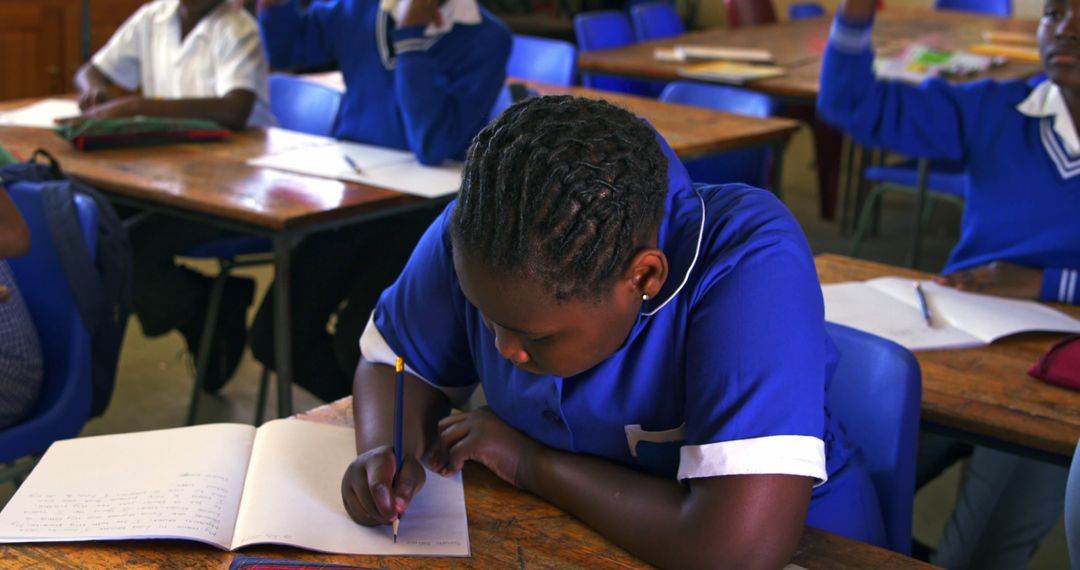 African Student Focused on Writing Assignment in Classroom - Free Images, Stock Photos and Pictures on Pikwizard.com