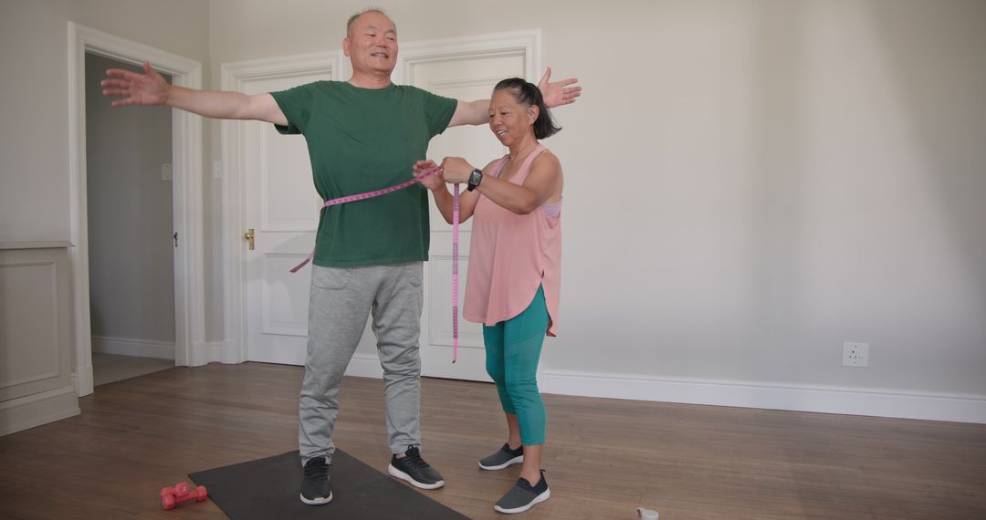 Smiling Senior Couple Measuring Fitness Progress at Home