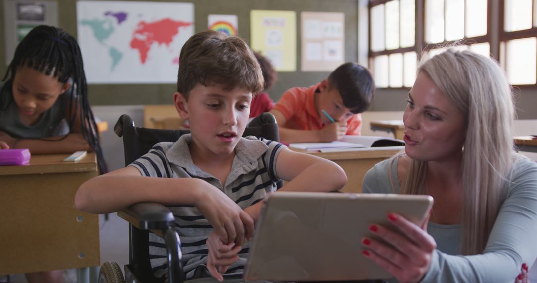 Teacher Helping Boy in Wheelchair with Tablet in Classroom - Free Images, Stock Photos and Pictures on Pikwizard.com