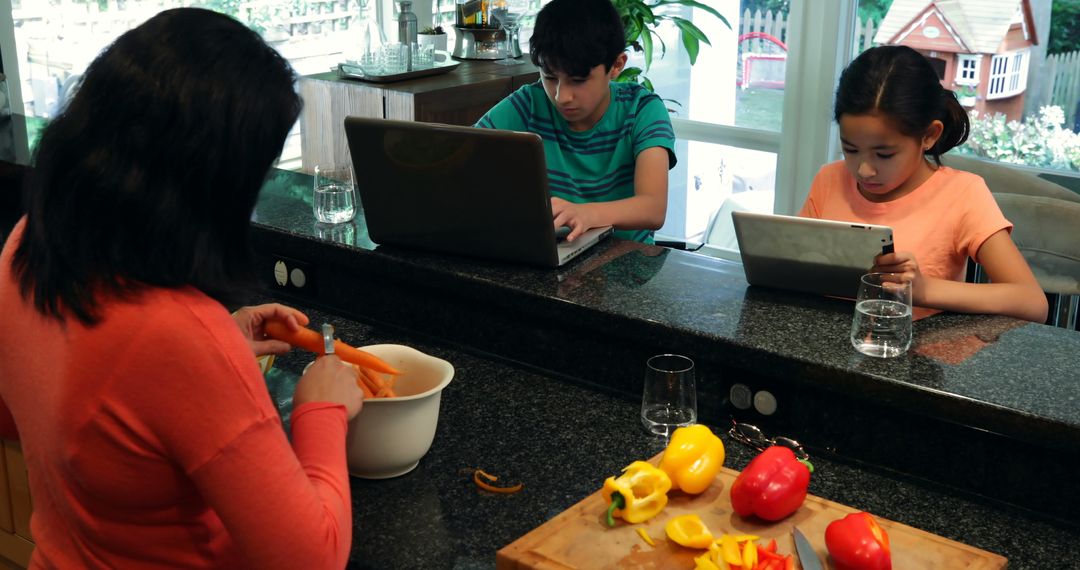 Mother Preparing Food While Children Using Gadgets in Kitchen - Free Images, Stock Photos and Pictures on Pikwizard.com