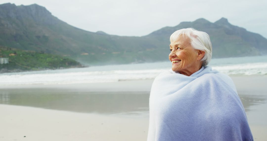 Smiling Senior Woman Enjoying Peaceful Beach View - Free Images, Stock Photos and Pictures on Pikwizard.com