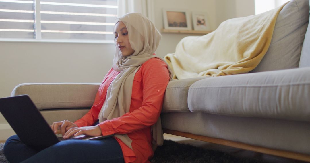 Focused Woman in Hijab Using Laptop at Home - Free Images, Stock Photos and Pictures on Pikwizard.com