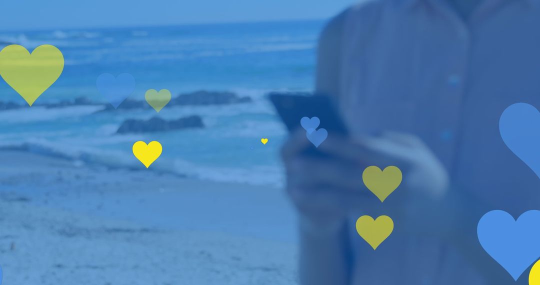 Person Holding Smartphone with Heart Graphics on a Beach