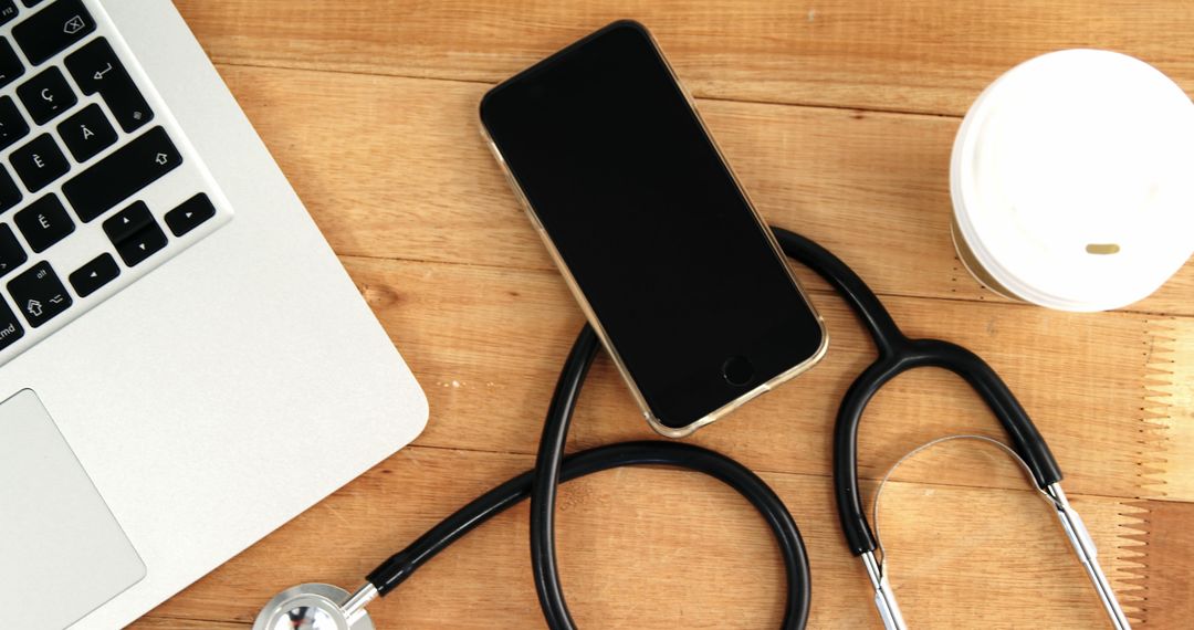 Stethoscope, Smartphone, Coffee Cup, and Laptop on Wooden Desk - Free Images, Stock Photos and Pictures on Pikwizard.com