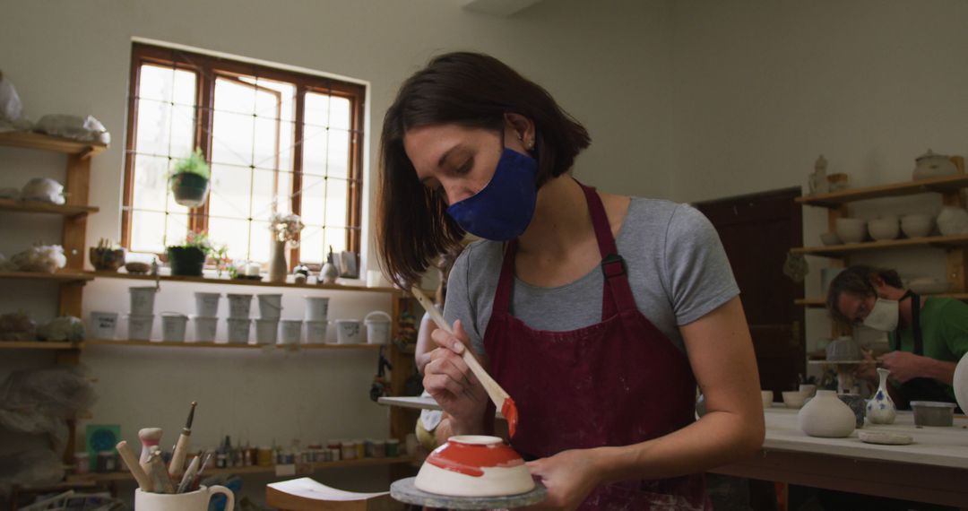 Woman Glazing Ceramics in Art Studio, Wearing Protective Face Mask - Free Images, Stock Photos and Pictures on Pikwizard.com