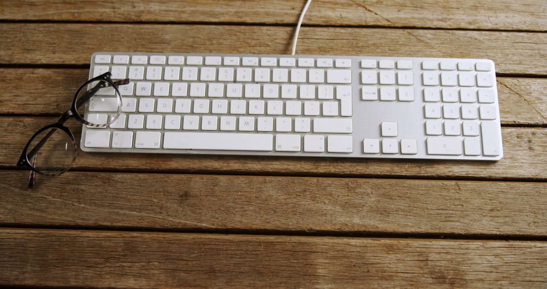 White Keyboard and Glasses on Wooden Table - Free Images, Stock Photos and Pictures on Pikwizard.com