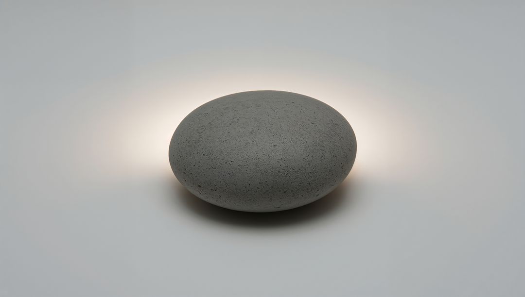Pebble Lamp Emitting Warm Halo on Minimal Concrete Tabletop, Sculptural Backlit Design
