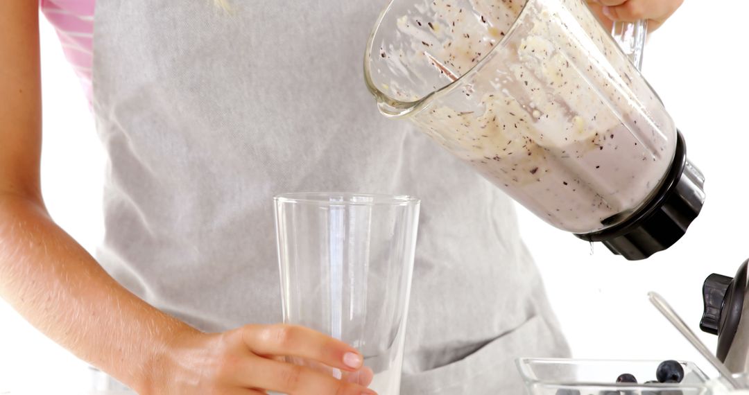 Person Pouring Blueberry Smoothie from Blender into Glass - Free Images, Stock Photos and Pictures on Pikwizard.com