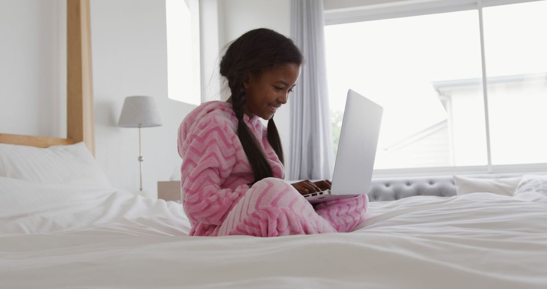 Young Girl in Pink Pajamas Using Laptop on Bed - Free Images, Stock Photos and Pictures on Pikwizard.com