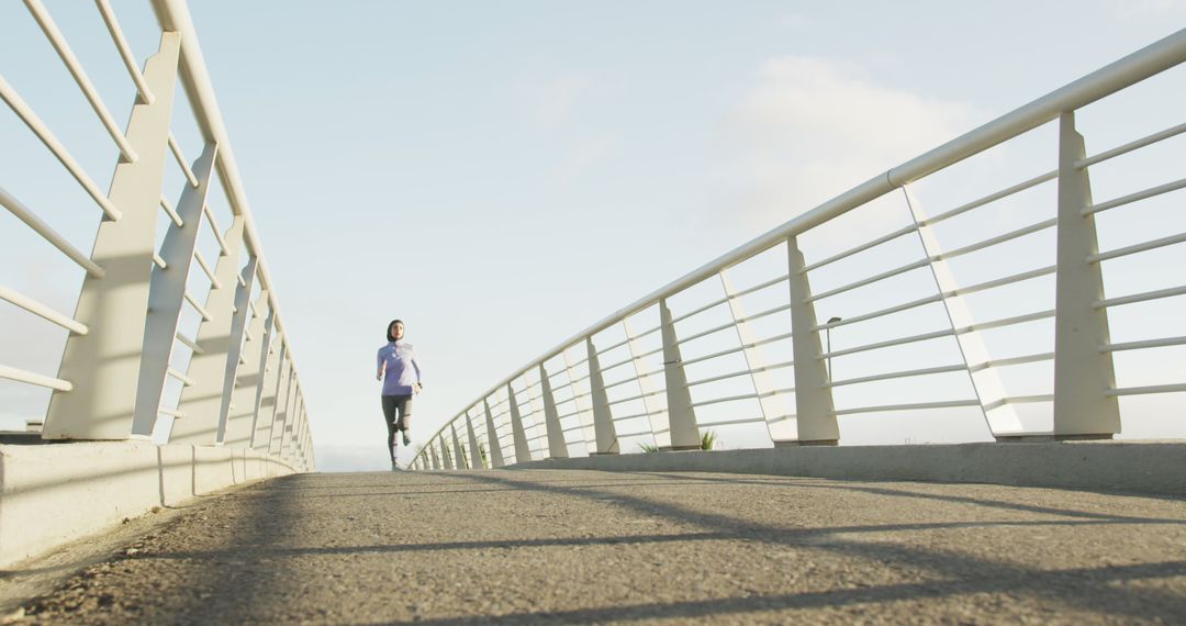 Woman Jogging on Bridge Experiencing Peaceful Morning Exercise - Free Images, Stock Photos and Pictures on Pikwizard.com