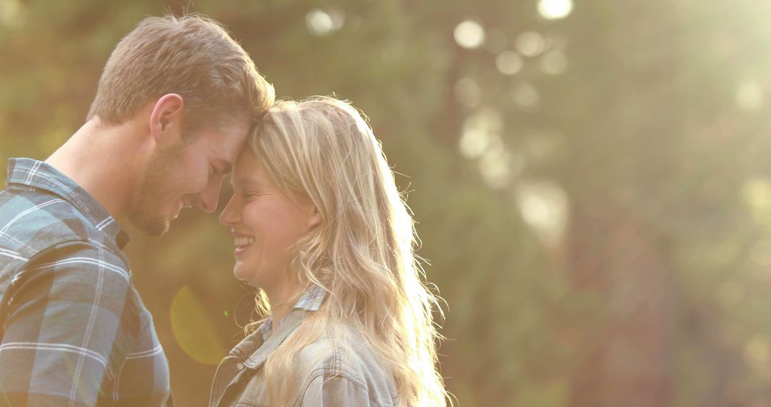 A young Caucasian couple shares a tender moment in a sunlit outdoor setting, with copy space - Free Images, Stock Photos and Pictures on Pikwizard.com